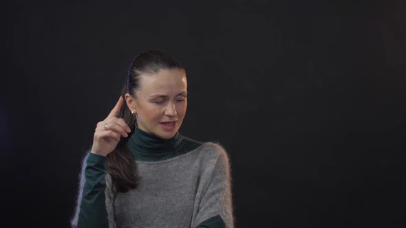 Serious Lady in Sweater and Blouse Poses Counting in Mind