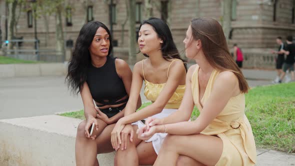 Three Young Candid Multiethnic Women Talking and Gossiping Outside