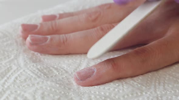 Close Up Woman Remove Old Gel From Nails with Nail File. Woman Getting Nail Manicure.