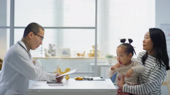 Asian Woman with Little Daughter Visiting Pediatrician