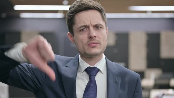 Portrait of Businessman with Laptop Showing Thumbs Down