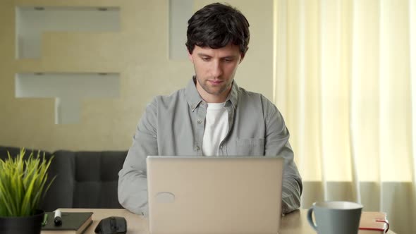 Smiling Man Using Laptop Studying Working Online at Home