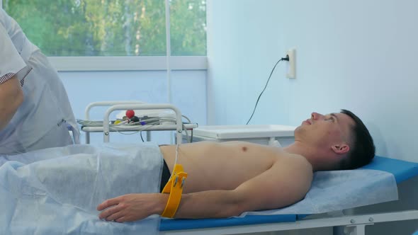 Nurse Performing Electrocardiography on a Male Patient