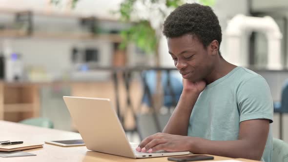 Tired Young African Man with Laptop Having Neck Pain