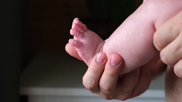 Father Holding Baby Feet in Hands