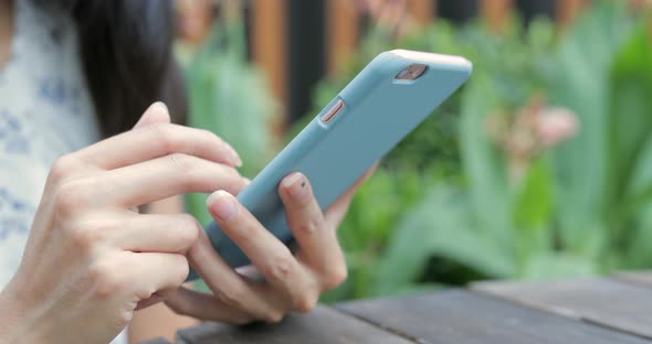 Woman using cellphone at outdoor cafe 