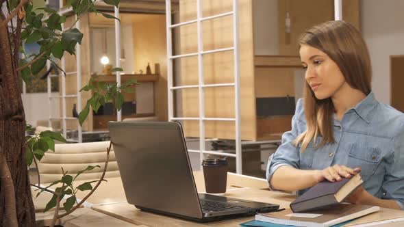 Girl Closes the Book at the Working Hub