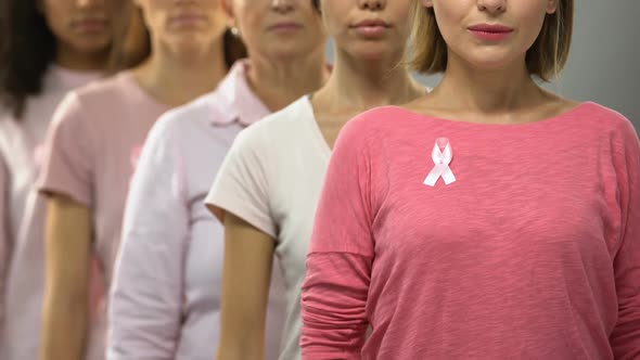 Group of Ladies With Pink Ribbons Recommending Timely Diagnosis of Breast Cancer