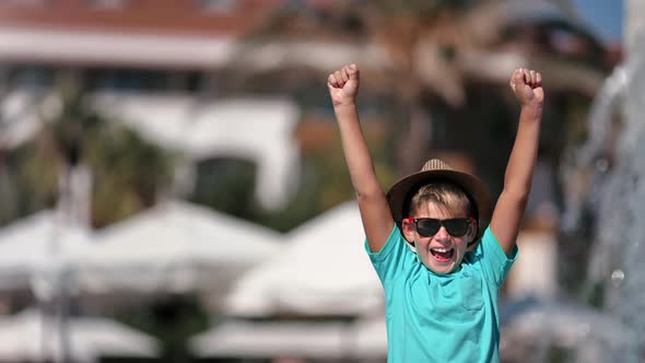 Portrait Laughing Boy Rejoicing Summer Travel Vacation with Raising Hands Swimming Pool Waterfall