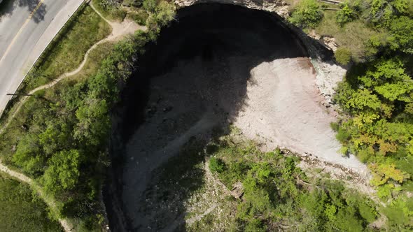 Aerial circle top down shot of famous Devil's Punch Bowl in Canadian Ontario during summer day.