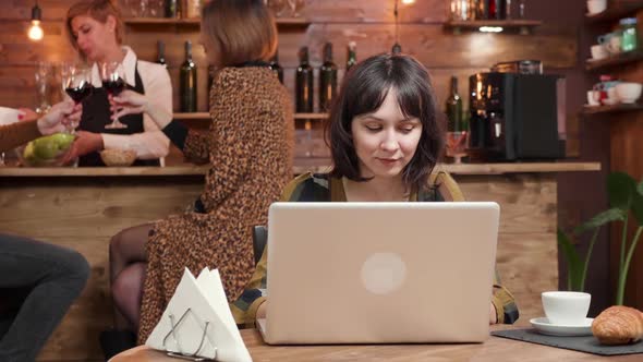 Young Female Designer Works on Her Project in a Coffee Shop