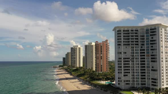 An aerial view of luxury apartments in Florida in front of the Atlantic Ocean. The camera boom up ov