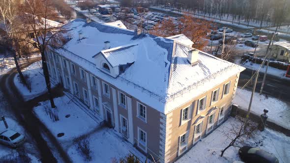 Building with Snow Capped Roof on City Street at Sunset