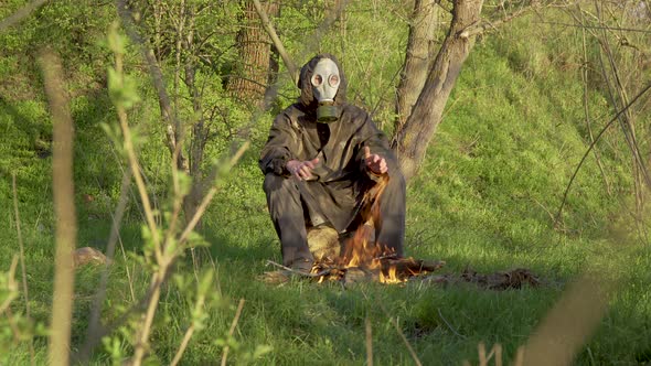 A Man in a Chemical Protection Suit Near a Fire