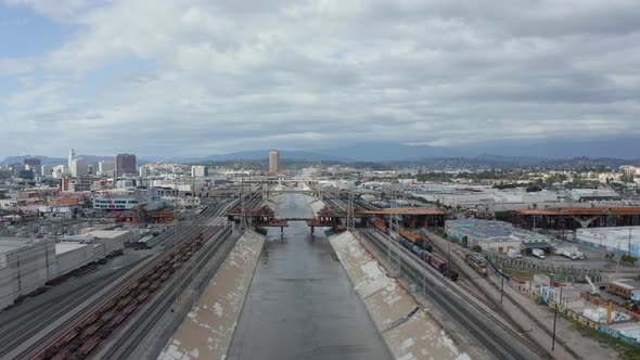 AERIAL: View Over Los Angeles River Bridge Being Built Under Construction Site with Overcast Cloudy alt