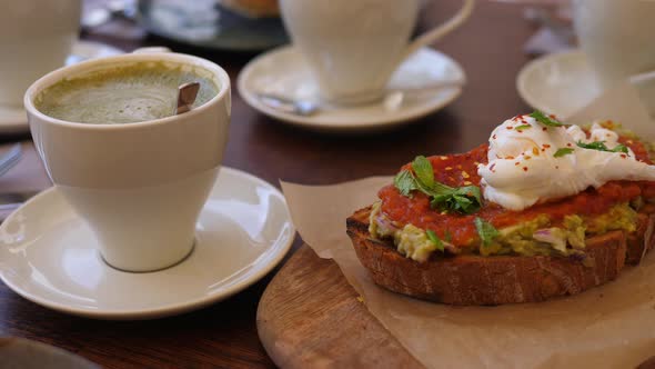 Wholegrain Toast with Avocado Spread with Shakshuka on Wooden Board Served with Coffee