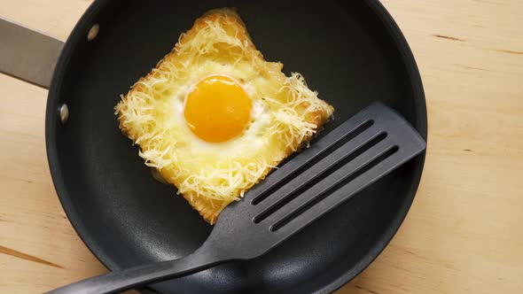 Top View of Toast with Fried Egg in Pan on Wooden Kitchen Table