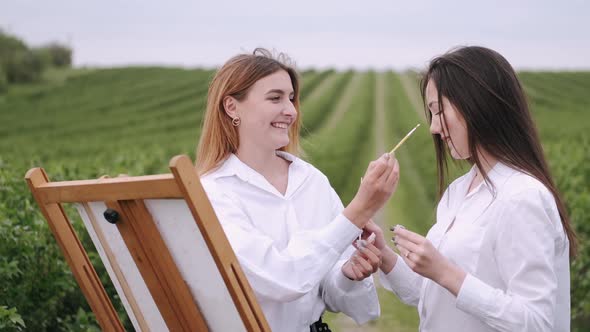 Elegant and Beautiful Girls Painting in a Field