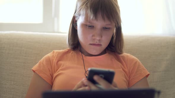 Teen Girl At Home On Couch Working In Tablet