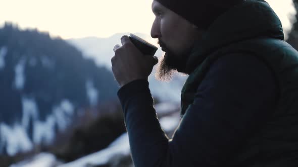 Bearded Man Drink Coffee in Winter Mountains