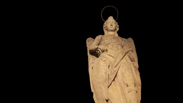 Pan Shot of Saint Raphael Statue at Night on the Roman Bridge of Cordoba