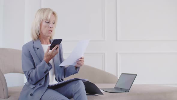 Woman Discussing Documents by Mobile Phone