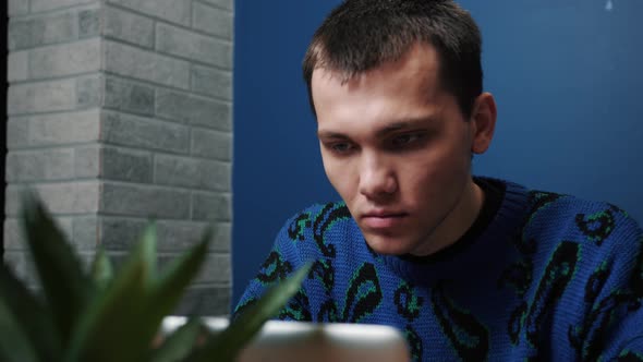 Focused Smiling Caucasian Man Work and Typing on a Laptop. Young Male Professional Using Laptop