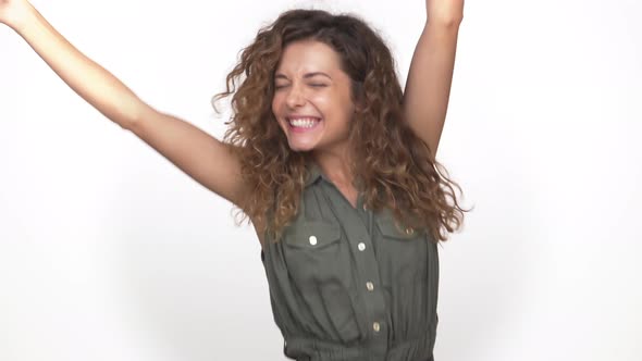 Young Energetic Curly Woman Suddenly Appearing on Camera Dancing Smiling Happily Isolated on White