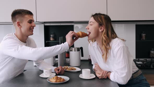 Smiling Couple Drinking Coffee in the Kitchen at Home