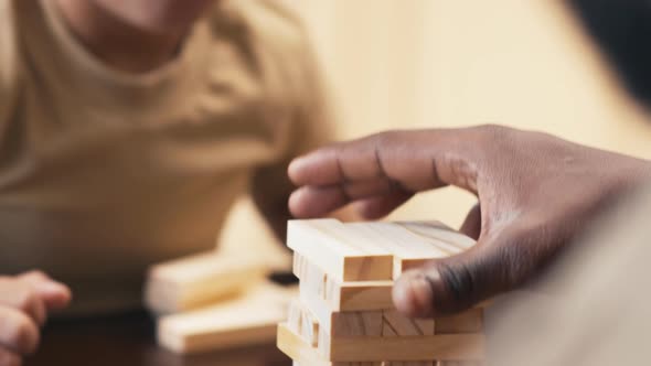 Biracial boy starting to play Jenga with adult man