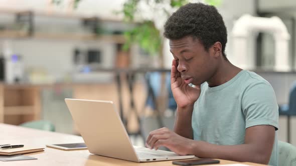Stressed Young African Man with Laptop Having Headache