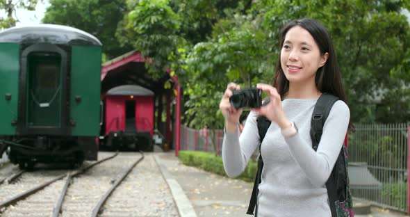 Woman traveling and taking photo in train station