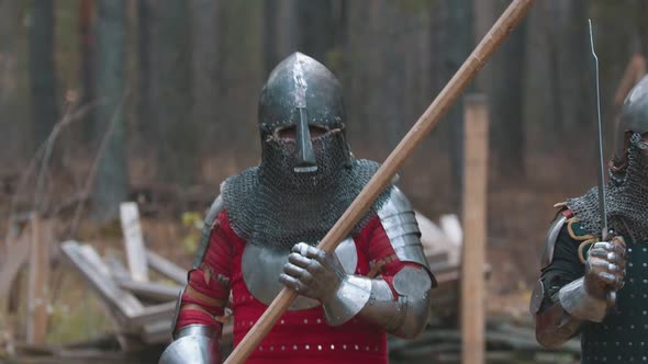 A Man Knight Walking in the Forest in Full Armour Holding a Weapon