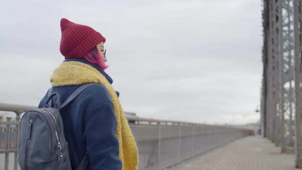 Back View of Female Tourist Walking on Urban Bridge