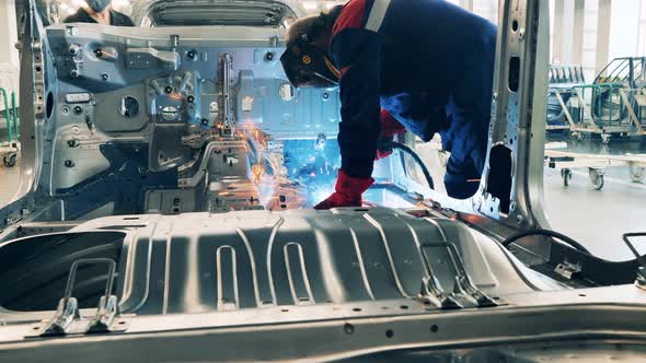 Car Body Is Getting Welded By a Plant Worker. Automobile Factory, Car Production, Auto Production