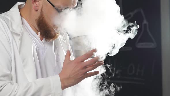 Chemical Show Using Liquid Nitrogen a Thick White Vapor Coming Out of a Glass Held in the Hands of a