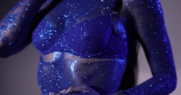 Woman with Blue Glitter Posing in a Studio