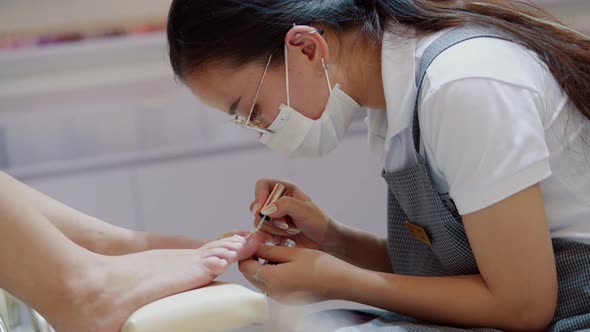 Cosmetologist Performs the Procedure Makes Brush Strokes Applies Red Varnish