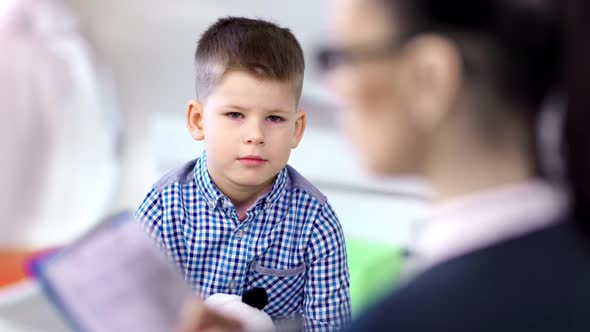 Over the Shoulder Shot Young European Boy Answering for Questions of Female Child Psychologist