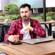 Bearded young man working at computer while having cup of coffee. - VideoHive Item for Sale