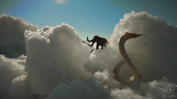 Figurine of a Mammoth on a Background of Snow