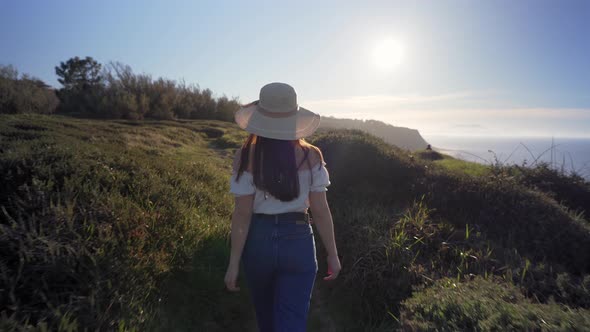 Woman walking on verdant grassy countryside