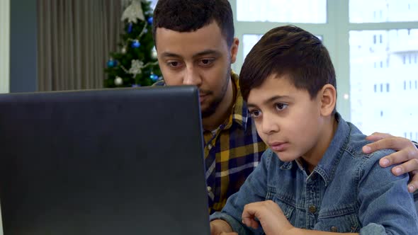 Father and Son Waving at the Laptop