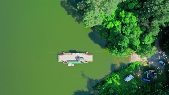 Ferry boat transporting a car across the river, aerial view