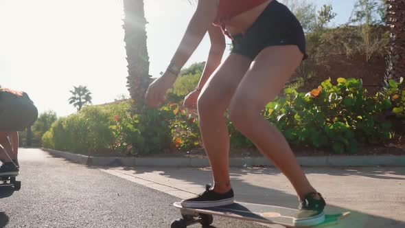 Summer on the Island of Young Girls on Longboard Rides in Short Shorts on the Road Near the Beach