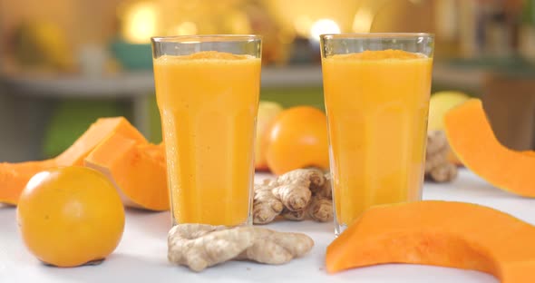 Pumpkin and Ginger Smoothie is Poured Into Glasses Against a Background of Fresh Vegetables and