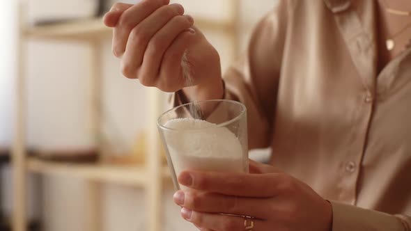 Closeup Cropped Shot of Female Artisan Pouring Dry Mixture By Hand Into Measuring Transparent Glass