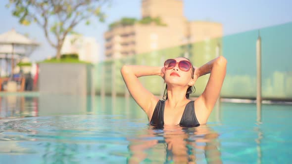 Young asian woman enjoy around outdoor swimming pool for leisure