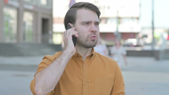 Angry Young Man Talking on Phone Outdoor