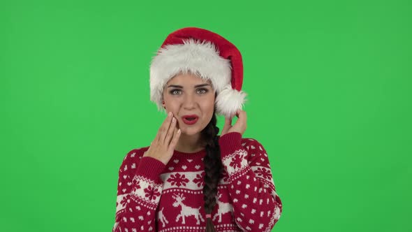 Portrait of Sweety Girl in Santa Claus Hat Is Saying Wow with Coquettishly Smile. Green Screen